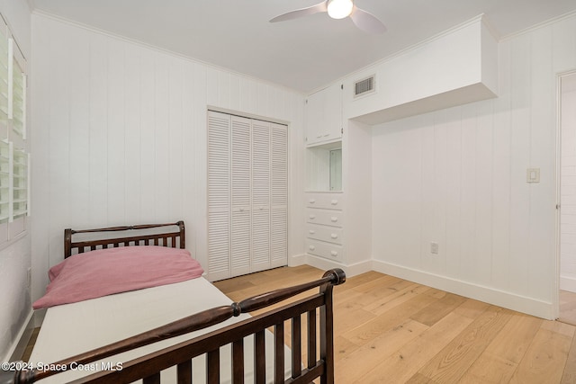 bedroom with a closet, ceiling fan, light hardwood / wood-style flooring, and crown molding