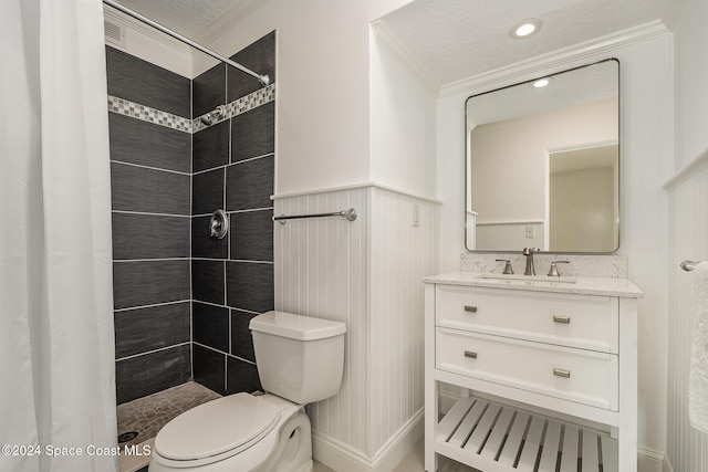 bathroom featuring vanity, crown molding, toilet, a textured ceiling, and a tile shower