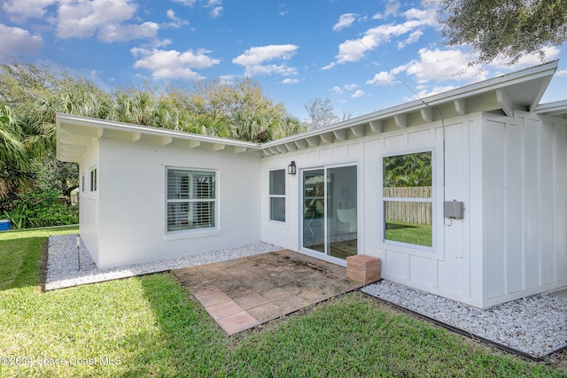 rear view of house featuring a patio area and a yard