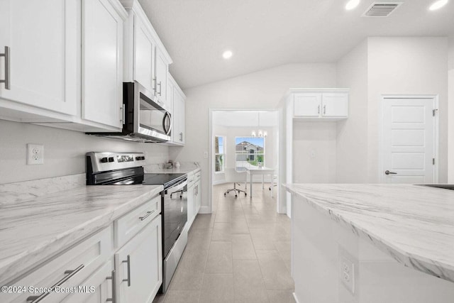 kitchen with light stone countertops, vaulted ceiling, white cabinetry, and appliances with stainless steel finishes