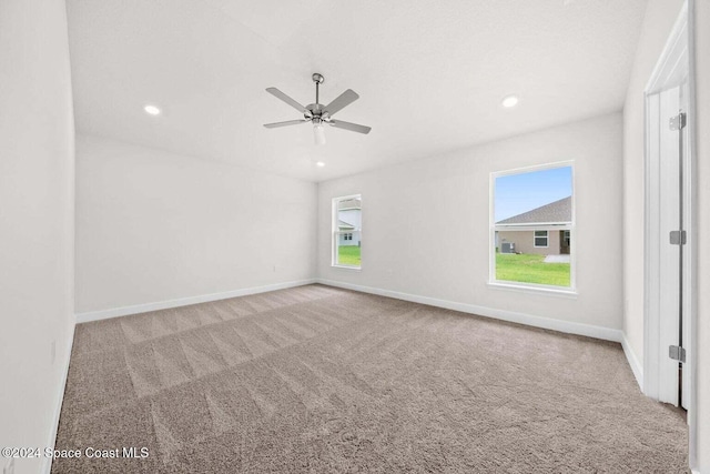 carpeted spare room with ceiling fan