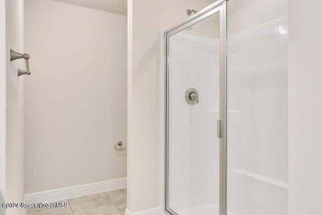 bathroom with walk in shower and tile patterned flooring