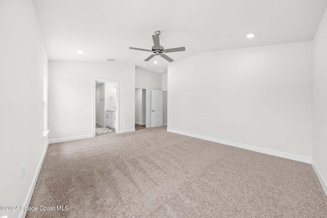 unfurnished bedroom with ceiling fan, connected bathroom, light carpet, and lofted ceiling