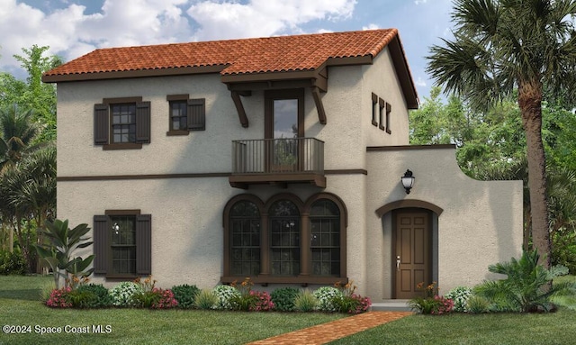 mediterranean / spanish-style house featuring a front yard and a balcony