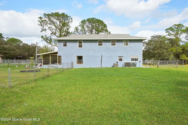 rear view of property with a lawn and central AC unit