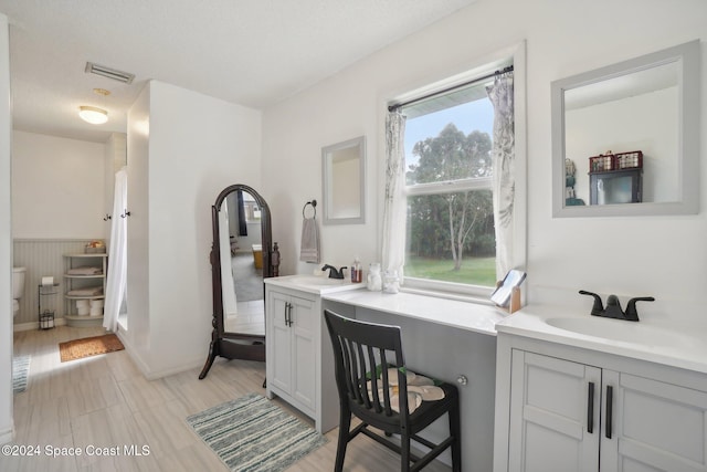 bathroom featuring a textured ceiling, vanity, and toilet