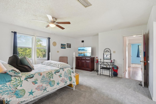 carpeted bedroom with a textured ceiling and ceiling fan