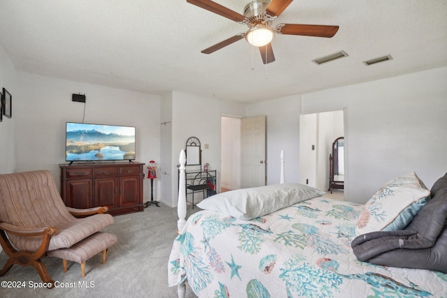 bedroom featuring a textured ceiling, ceiling fan, and light carpet