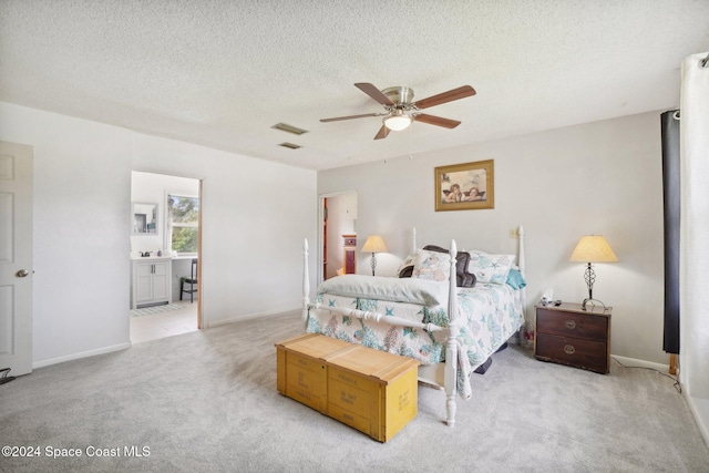 bedroom with a textured ceiling, ceiling fan, and light carpet