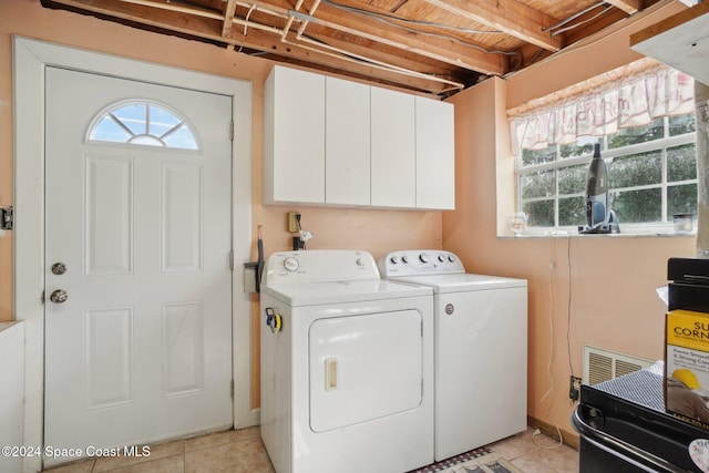 laundry area with cabinets, light tile patterned floors, washing machine and dryer, and wood ceiling