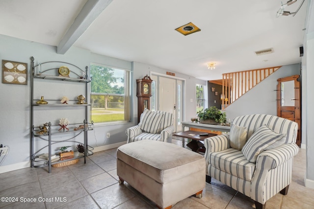 living area featuring tile patterned flooring and beam ceiling