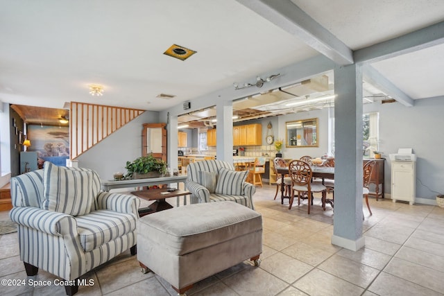 living room featuring beam ceiling and light tile patterned floors