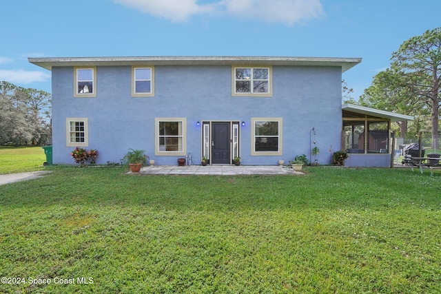 rear view of property featuring a lawn and a sunroom