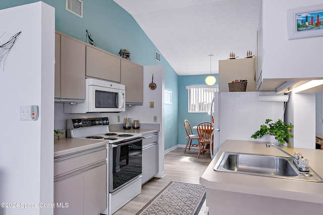 kitchen featuring white appliances, a sink, visible vents, light countertops, and decorative light fixtures