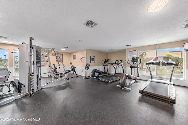 workout area featuring a textured ceiling and visible vents