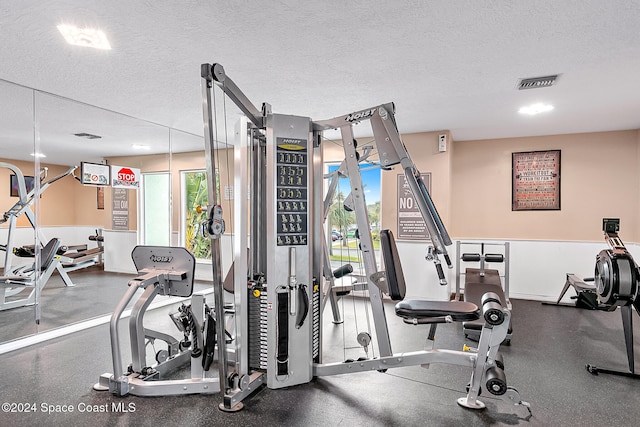 gym featuring visible vents and a textured ceiling