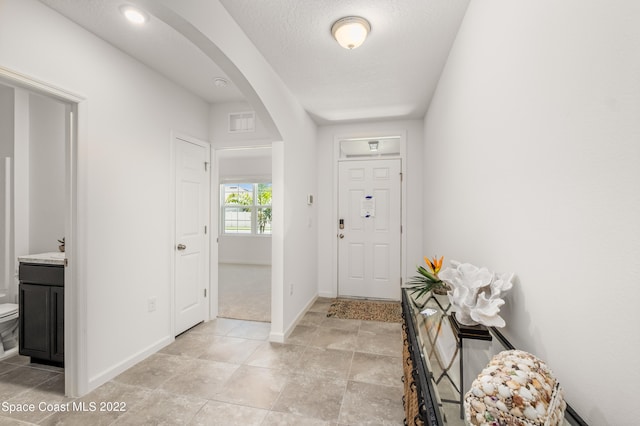 entryway with baseboard heating and a textured ceiling