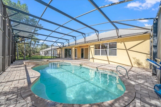 view of pool featuring glass enclosure, ceiling fan, and a patio