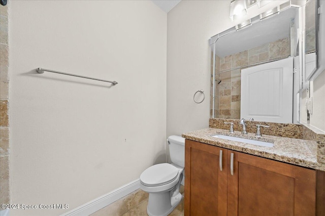 bathroom featuring tile patterned floors, vanity, toilet, and a tile shower