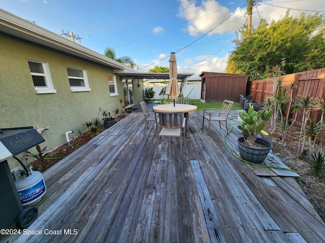 deck featuring a shed and grilling area