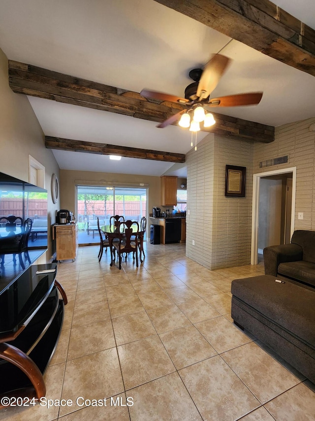 dining area with light tile patterned floors, ceiling fan, brick wall, and vaulted ceiling with beams