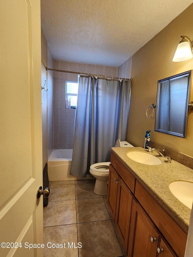 full bathroom featuring shower / bath combination with curtain, vanity, a textured ceiling, tile patterned flooring, and toilet