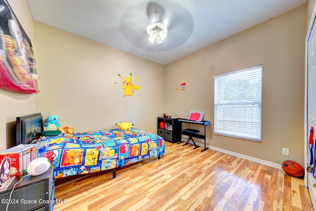 bedroom with ceiling fan, a textured ceiling, and wood-type flooring