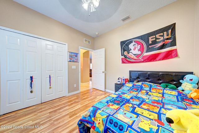 bedroom featuring a textured ceiling, hardwood / wood-style flooring, ceiling fan, and a closet