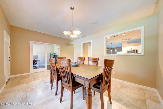 tiled dining area with a notable chandelier