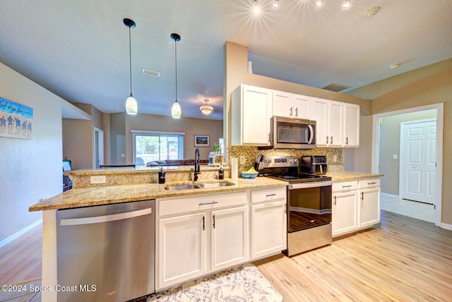 kitchen with stainless steel appliances, white cabinetry, sink, and light wood-type flooring