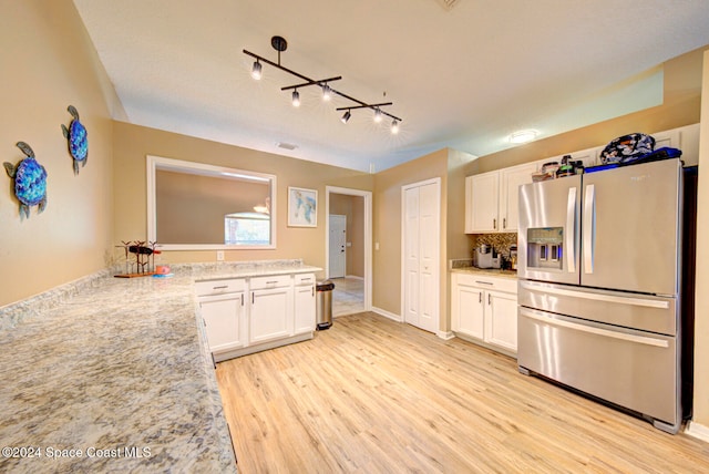 kitchen with light stone countertops, rail lighting, white cabinets, stainless steel fridge with ice dispenser, and light wood-type flooring