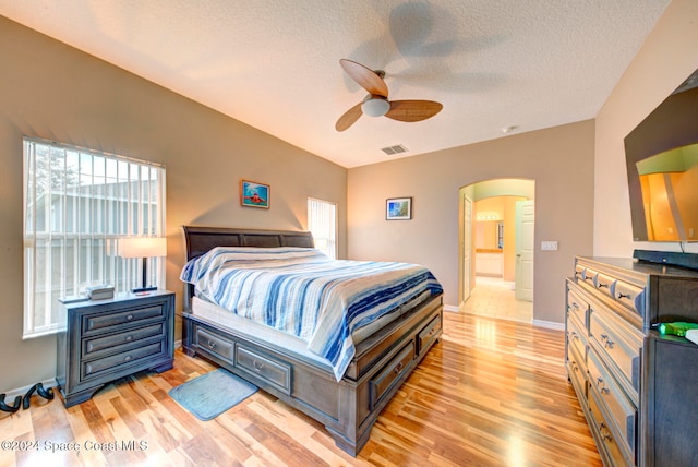 bedroom featuring a textured ceiling, light hardwood / wood-style flooring, and ceiling fan