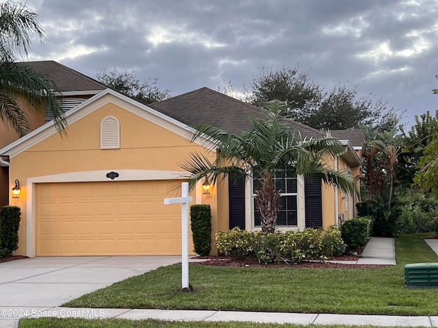 view of front of house with a garage and a front lawn