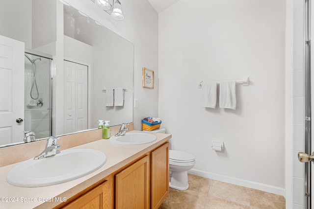 bathroom with tile patterned flooring, vanity, an enclosed shower, and toilet