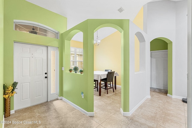 foyer entrance featuring light tile patterned floors and a notable chandelier