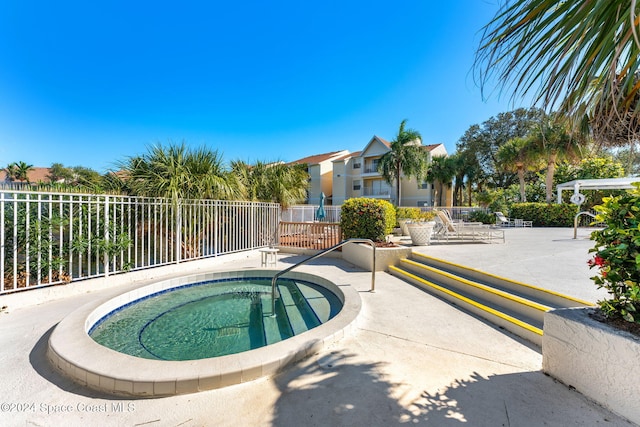 view of swimming pool with a hot tub and a patio area