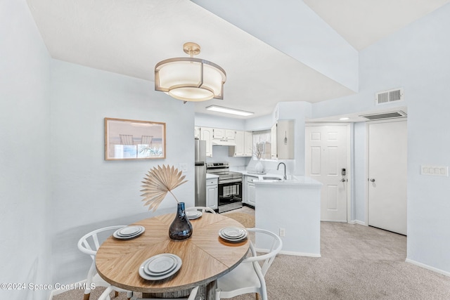 dining room featuring light carpet, lofted ceiling, and sink