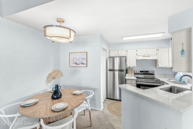 kitchen with sink, stainless steel appliances, light stone counters, kitchen peninsula, and white cabinets