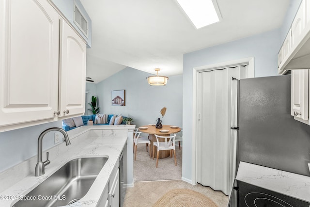 kitchen with stainless steel refrigerator, white cabinetry, sink, ventilation hood, and decorative light fixtures