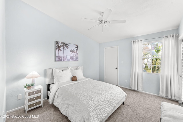 carpeted bedroom with ceiling fan and vaulted ceiling