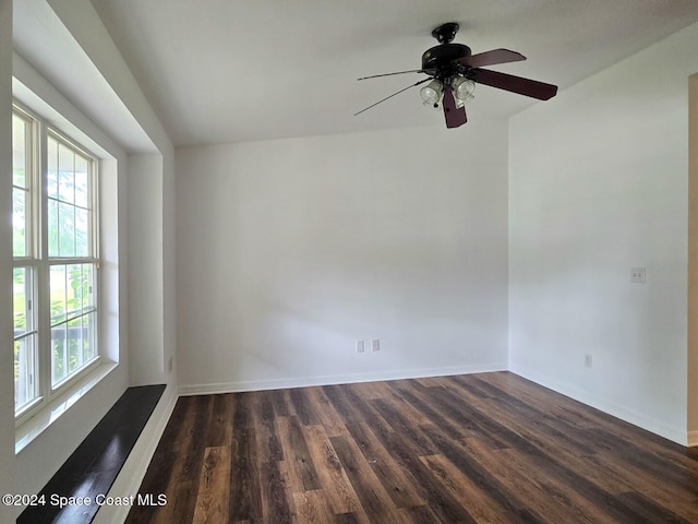 empty room with dark hardwood / wood-style flooring and ceiling fan