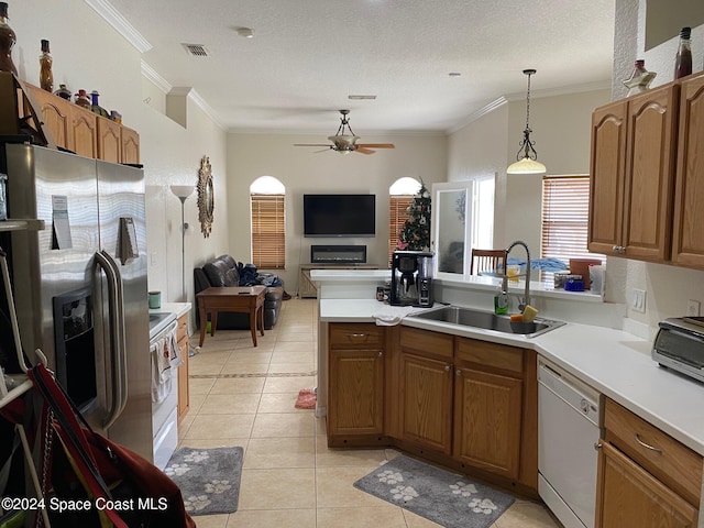 kitchen with white appliances, a textured ceiling, crown molding, sink, and pendant lighting