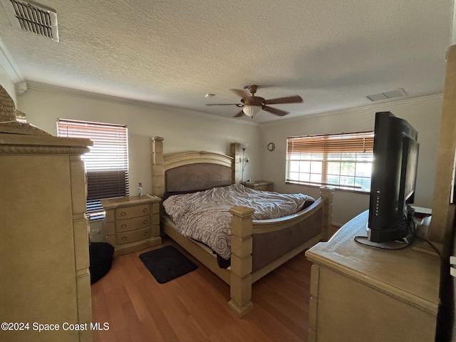 bedroom featuring ceiling fan, light hardwood / wood-style flooring, crown molding, and a textured ceiling