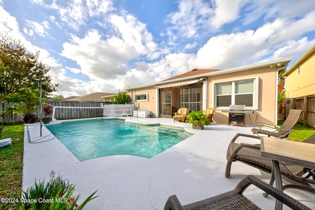 view of swimming pool with a grill and a patio