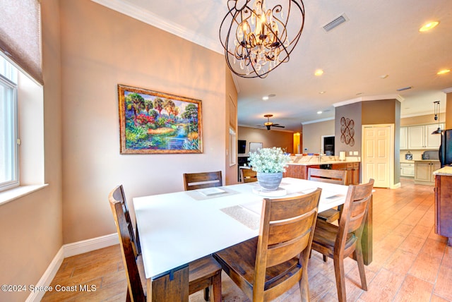 dining area with ornamental molding, ceiling fan with notable chandelier, and light hardwood / wood-style flooring