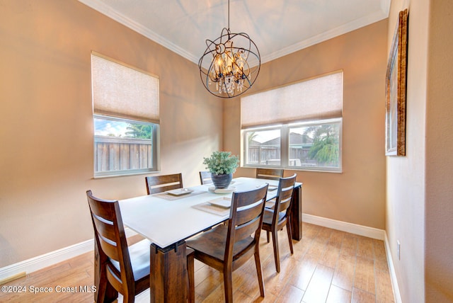 dining area featuring a notable chandelier, crown molding, and light wood-type flooring