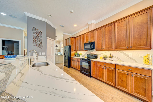 kitchen with sink, light stone counters, crown molding, light hardwood / wood-style floors, and black appliances