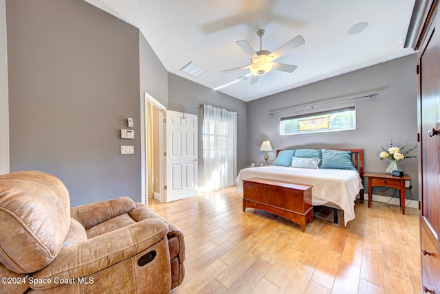 bedroom with ceiling fan, light hardwood / wood-style floors, and a textured ceiling