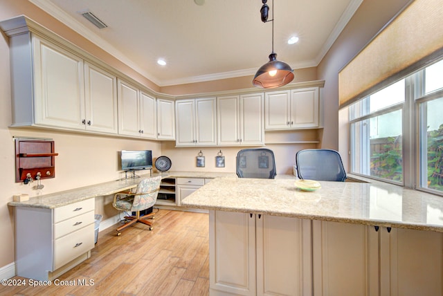 office with crown molding, built in desk, and light wood-type flooring