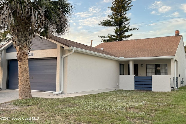 view of front of home with a front yard and a garage